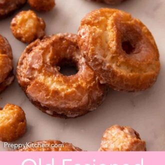 Pinterest graphic of two old fashioned donuts, one propped on top of the other and surrounded by donut holes.