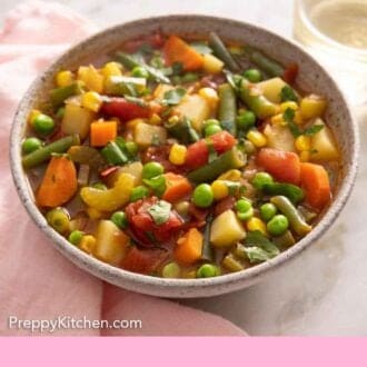 Pinterest graphic of a bowl of vegetable soup by a linen napkin.