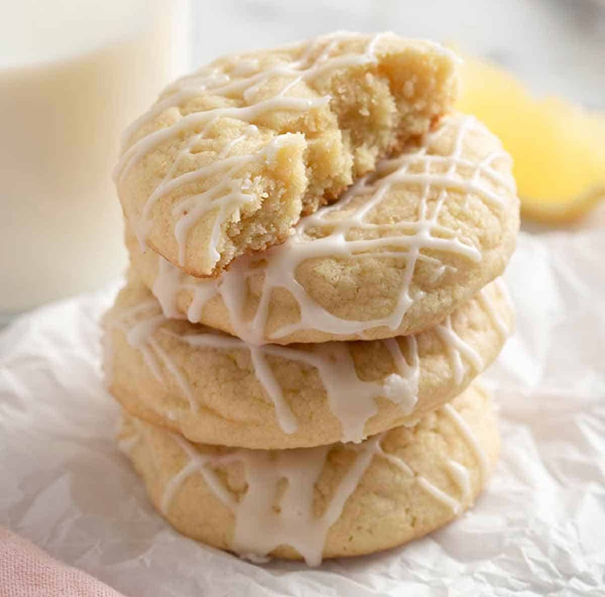 A stack of four lemon cookies with a bite taken out of the first one.