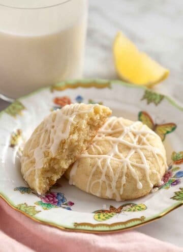 A plate with two lemon cookies, on cut in half.
