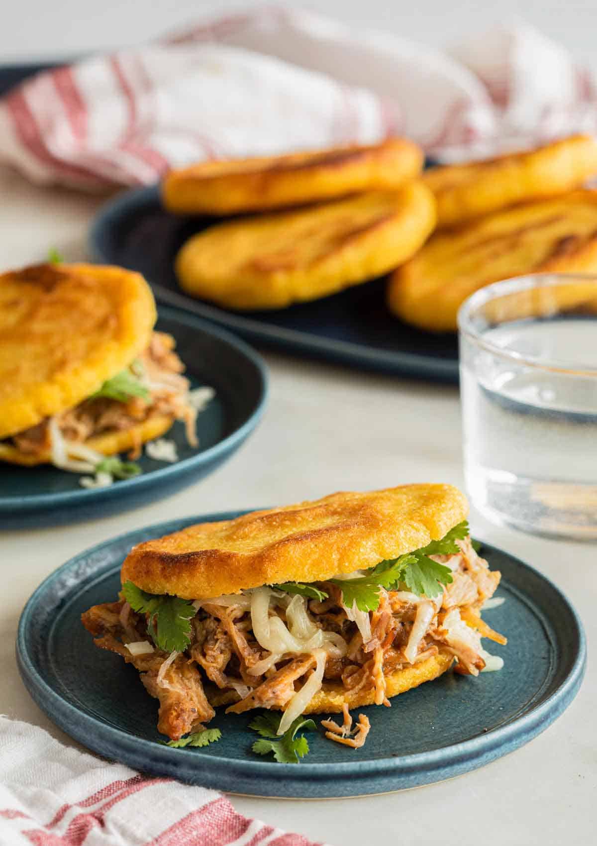 A plate with an arepa stuffed with shredded meat.
