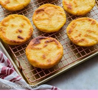Pinterest graphic of multiple arepas on a cooling rack.