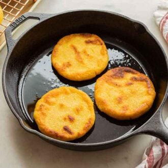 A cast iron with three arepas.