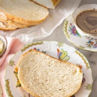 Pinterest graphic of a plate with a slice of artisan bread with more in the background.