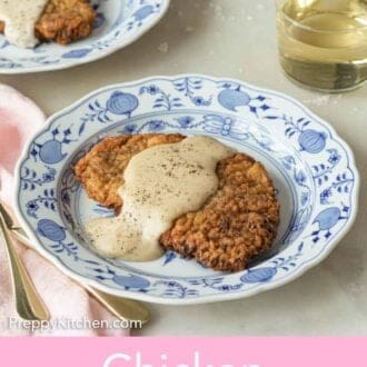 Pinterest graphic of a plate with chicken fried steak and gravy, by a glass of wine.