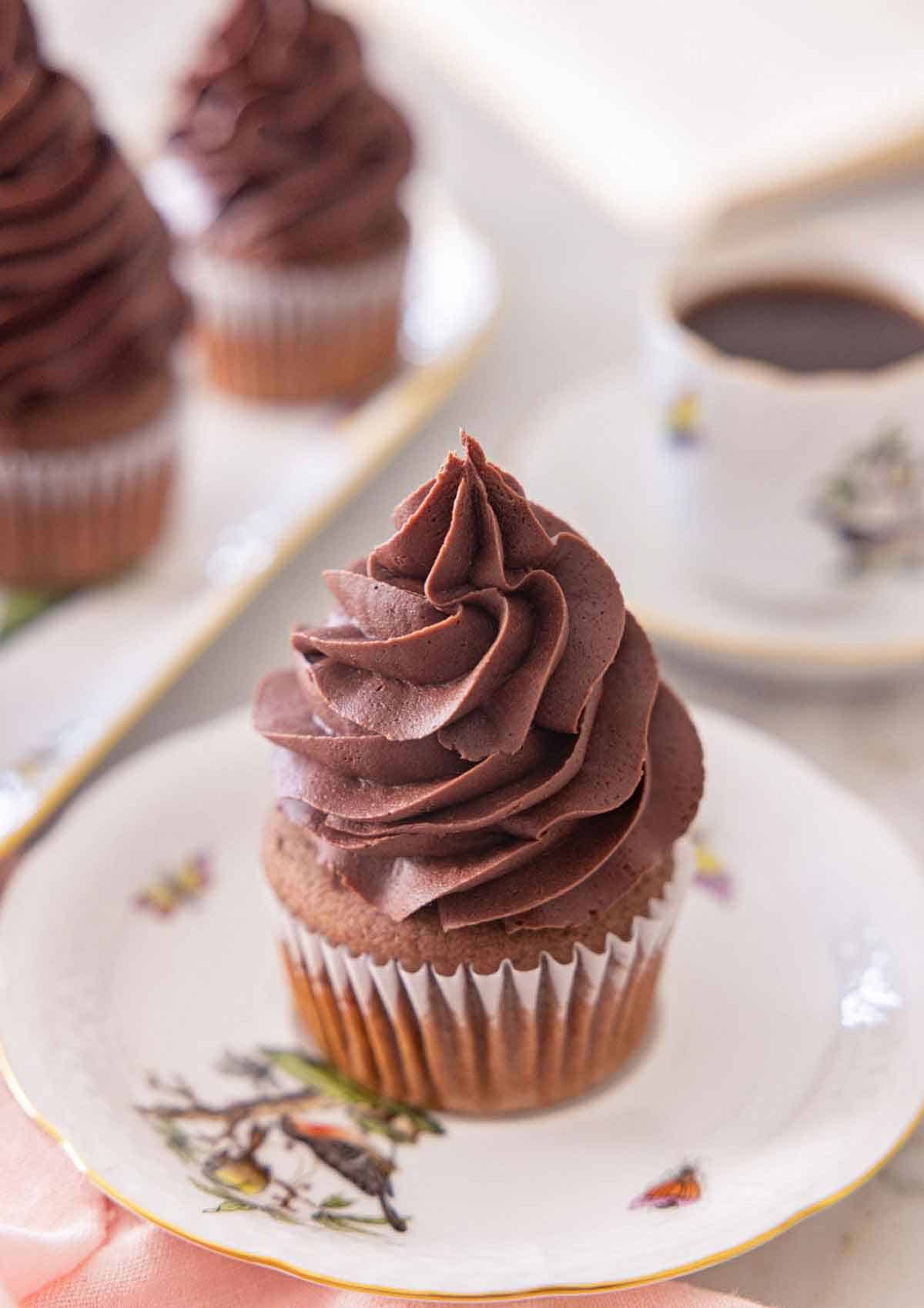 A cupcake with chocolate buttercream frosting piped on top.