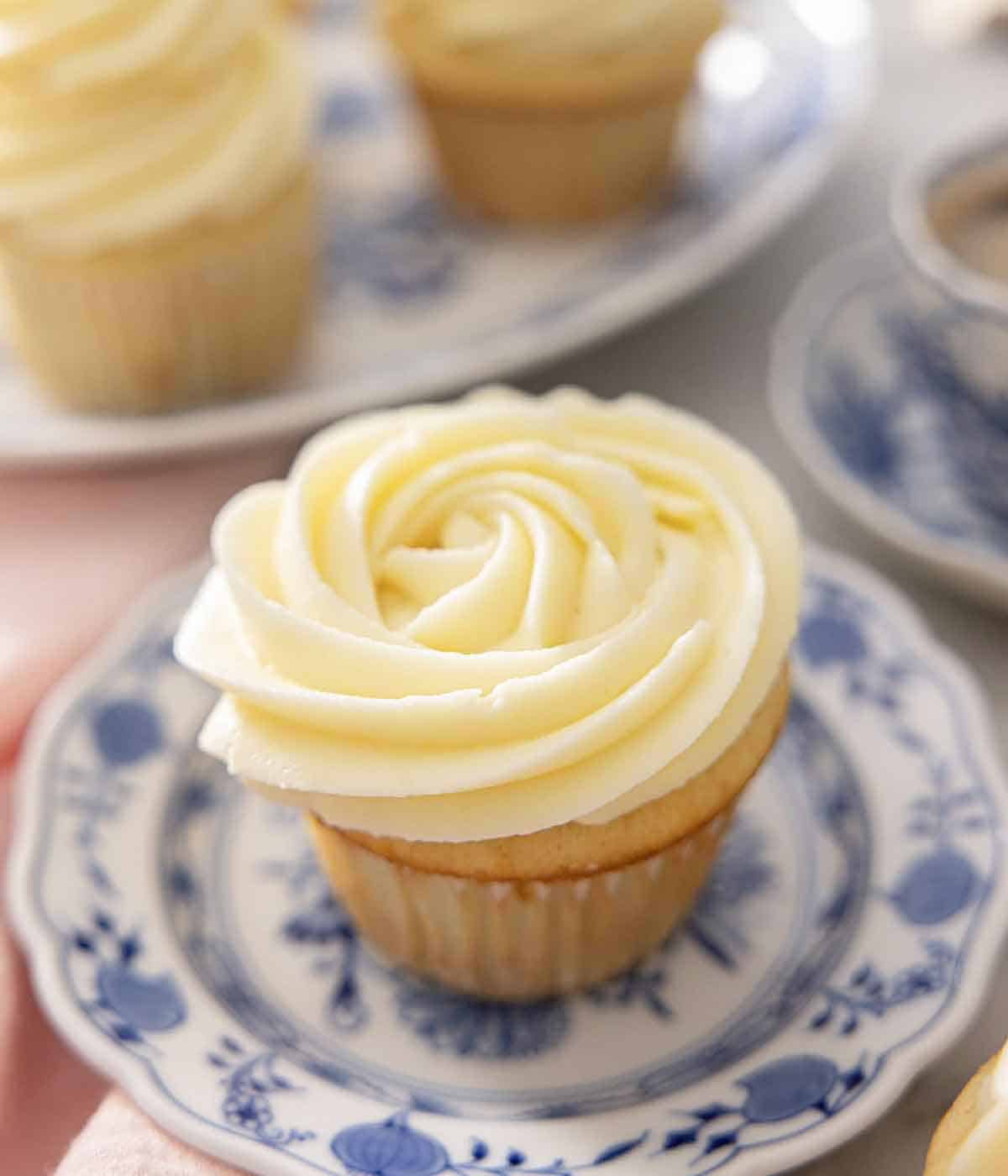 A cupcake with cream cheese frosting piped on top.