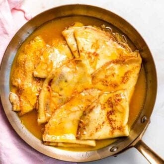 Overhead view of multiple crepe suzette in a pan.