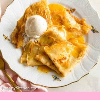 Pinterest graphic of a plate with crepe suzette with a scoop of ice cream.