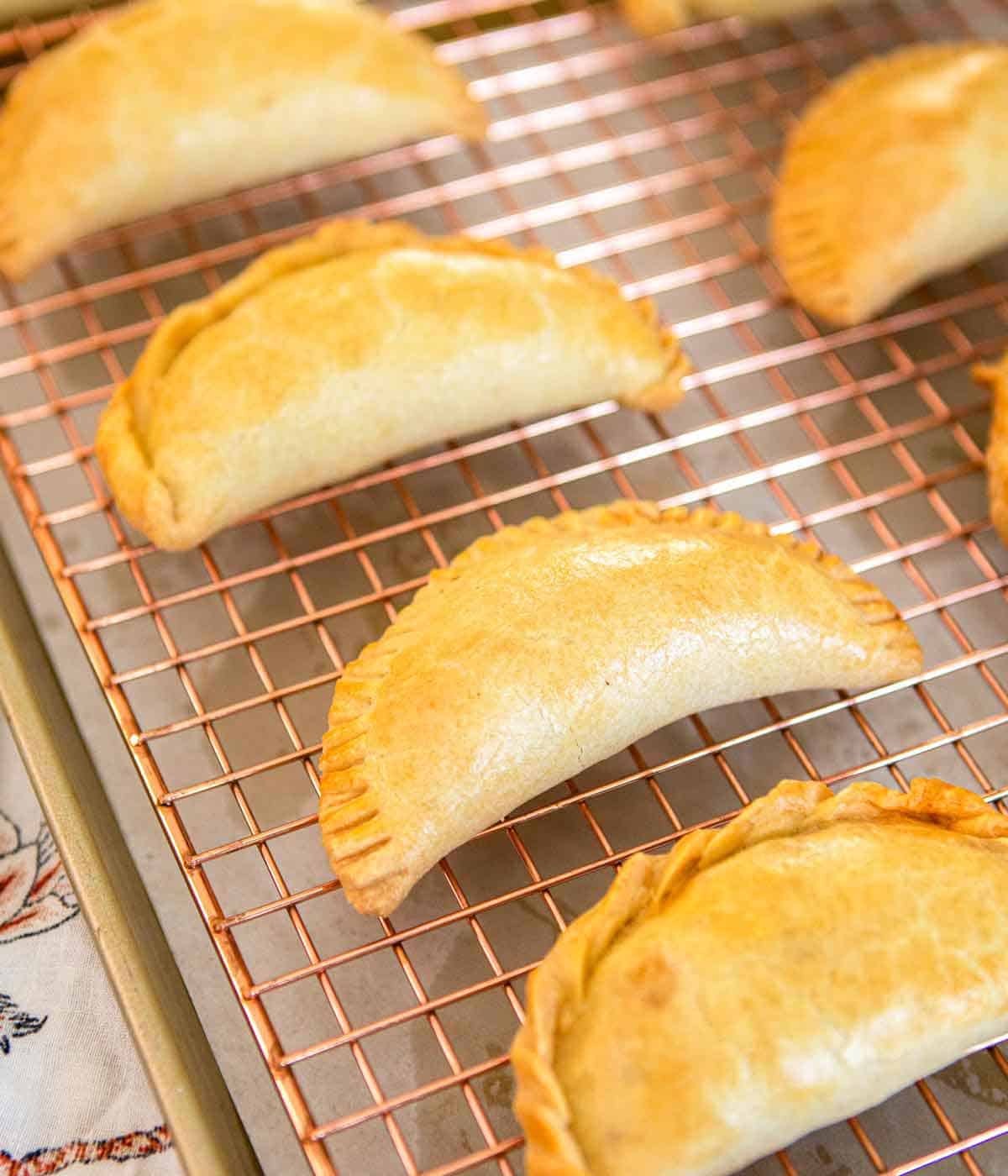 Multiple empanadas on a wire cooling rack.
