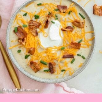 Pinterest graphic of an overhead view of a bowl of potato soup with cheese, bacon, sour cream, and chives on top.