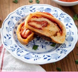 Pinterest graphic of a plate with two slices of stromboli on a plate in front of a bowl of sauce.