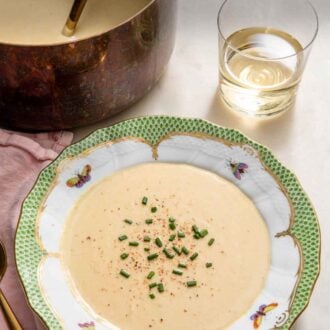 Pinterest graphic of a bowl of vichyssoise by a pot of soup and wine.