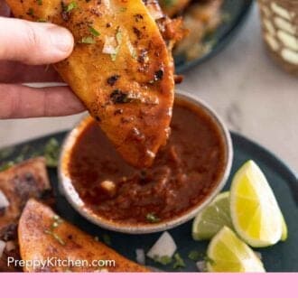 Pinterest graphic of a birria taco dipped into sauce.