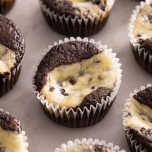 Multiple black bottom cupcakes on a marble surface.