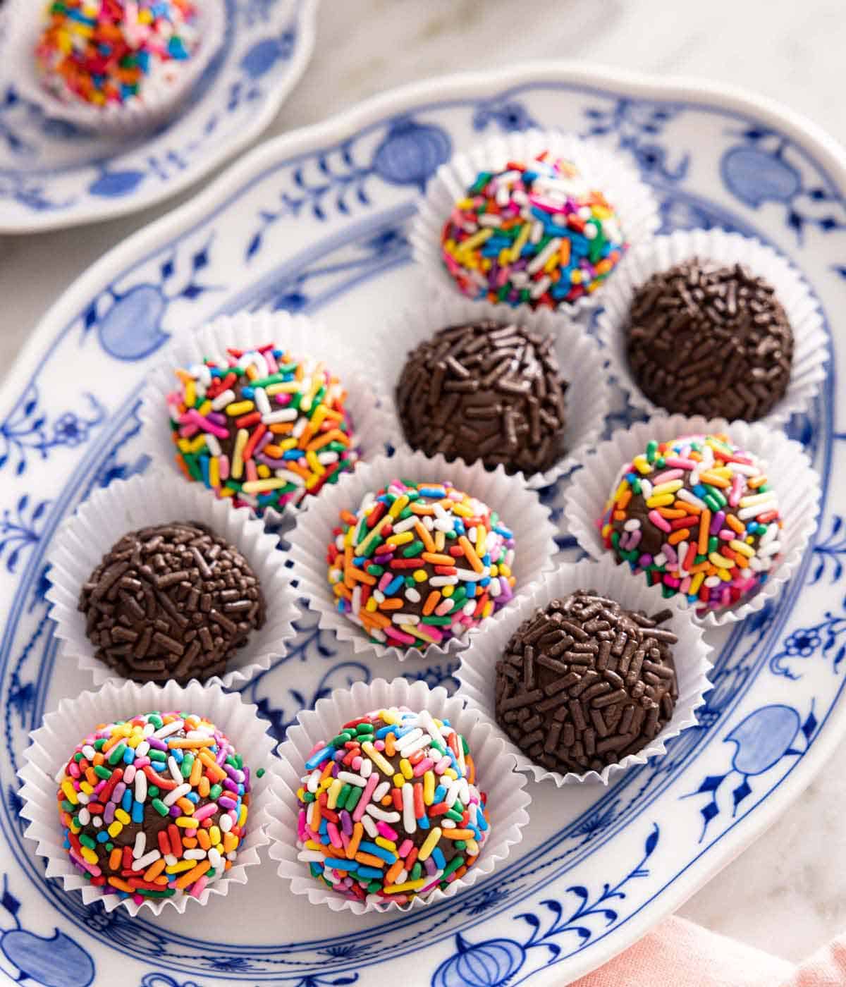 A platter of brigadeiros with assorted sprinkles coating them.
