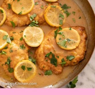 Pinterest graphic of a skillet of chicken Francese with lemon slices and parsley on top.