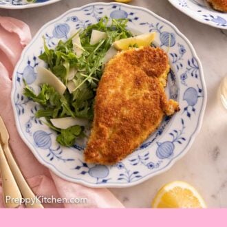 Pinterest graphic of an overhead view of a plate of chicken Milanese with arugula salad.