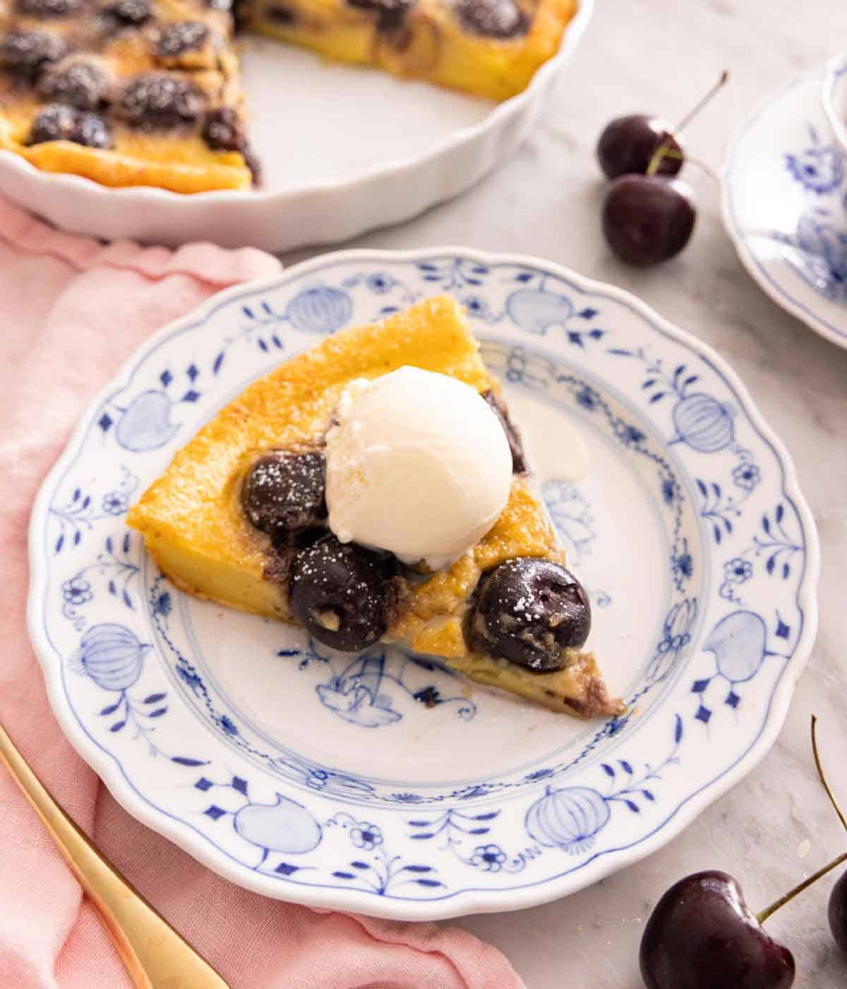 A slice of clafoutis with vanilla ice cream on top.