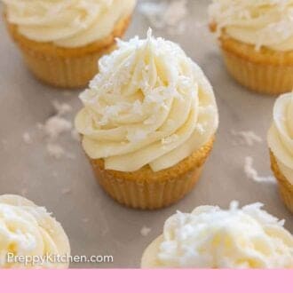Pinterest graphic of multiple coconut cupcakes with shredded coconut flakes sprinkled on top.