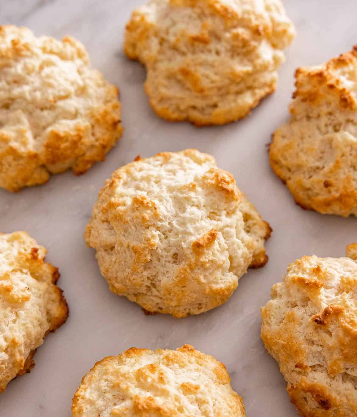 Multiple drop biscuits in a single layer on a marble surface.