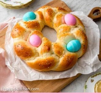 Pinterest graphic of a serving board lined with parchment with Easter bread on top.