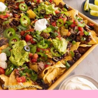 Pinterest graphic of a sheet pan of nachos with bowls of toppings on the side.