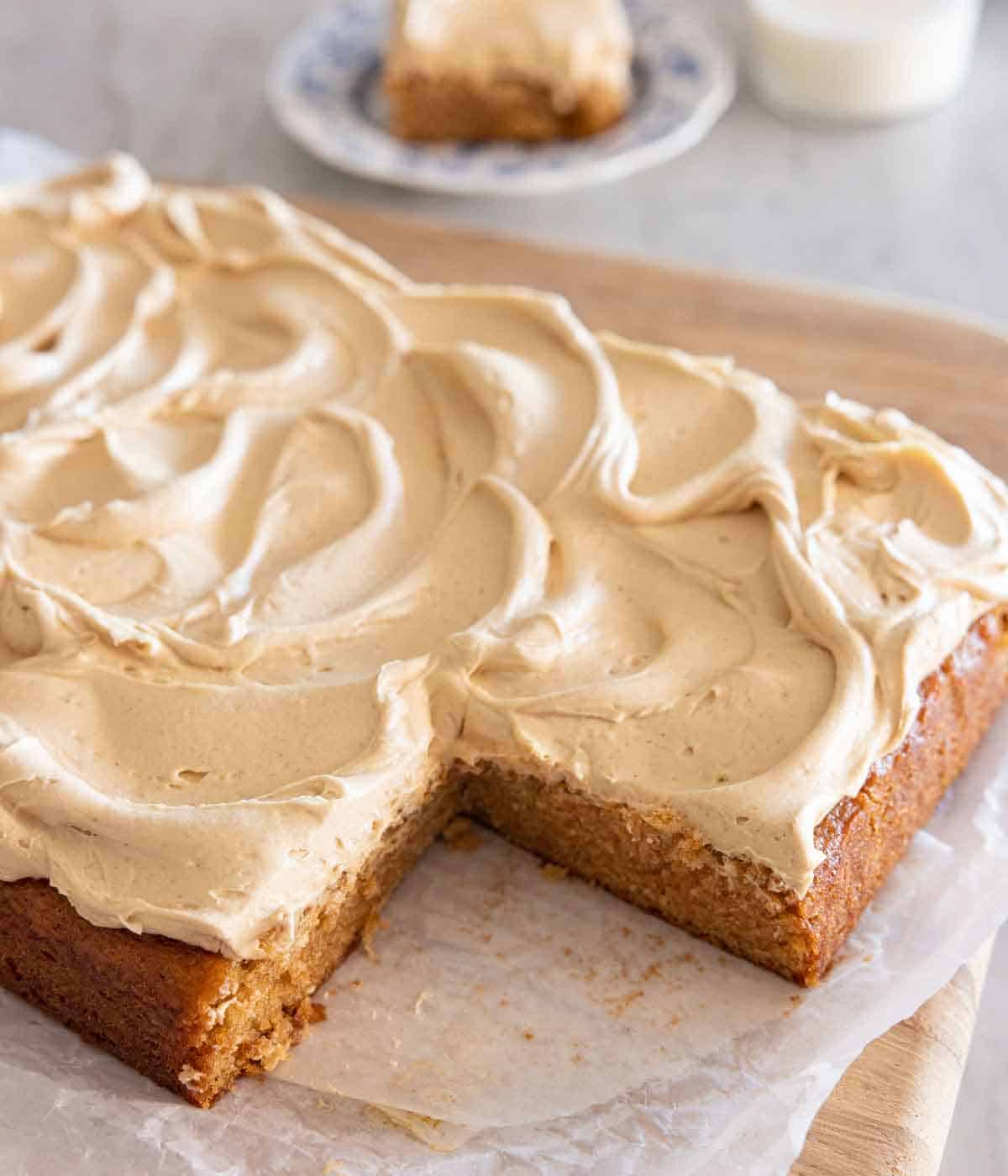 A peanut butter cake with a slice cut out, on top of a serving board.