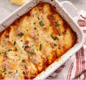 Pinterest graphic of an overhead view of stuffed shells in a white baking dish by some plates.