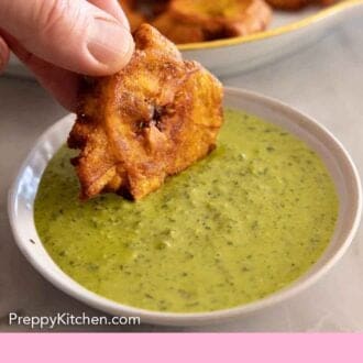 Pinterest graphic of tostone dipped into a green garlic sauce.