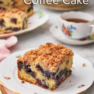 Pinterest graphic of a plate with a serving of blueberry coffee cake by a cup of coffee.