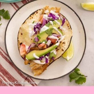 Pinterest graphic of an overhead view of a plate of a fish taco with a lime wedge beside it.