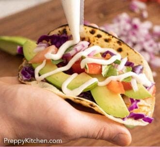 Pinterest graphic of fish taco sauce drizzled over a taco.