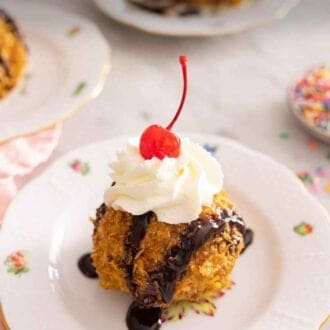 Pinterest graphic of a plate with a serving of fried ice cream with whipped cream and a cherry on top.