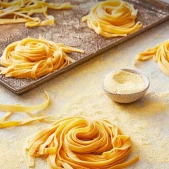 Pinterest graphic of bundles of long stranded pasta on a counter and on a sheet pan.