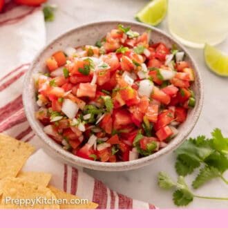Pinterest graphic of a bowl of pico de gallo by a drink and additional ingredients.