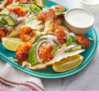 Pinterest graphic of a platter of shrimp tacos with dip on the side.