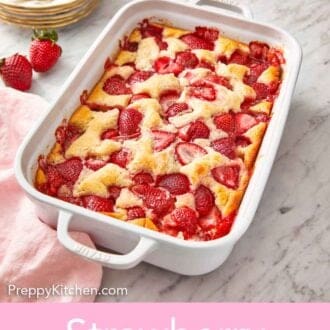 Pinterest graphic of a white baking dish of strawberry cobbler.
