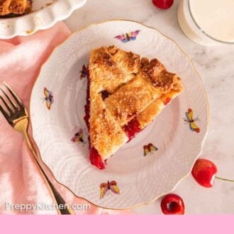 Pinterest graphic of an overhead view of a slice of cherry pie beside a glass of milk with cherries scattered around.
