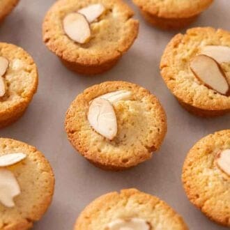 Rows of financiers with two sliced almonds on top of each of them.