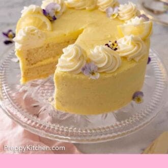 Pinterest graphic of a lemon cake on a clear cake stand with a slice cut out.