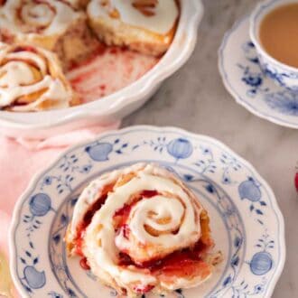 Pinterest graphic of a plate with a strawberry roll on it with a baking dish with the rest of the strawberry rolls in the background.