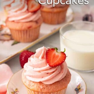 Pinterest graphic of a strawberry cupcake in front of a cup of milk and platter of cupcakes in the background.