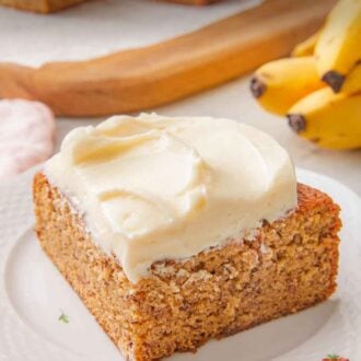 Pinterest graphic of a plate with a slice of banana cake with the rest of the cake and bananas in the background.