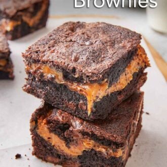 Pinterest graphic of a lined serving board with two square caramel brownies stacked on top of each other.