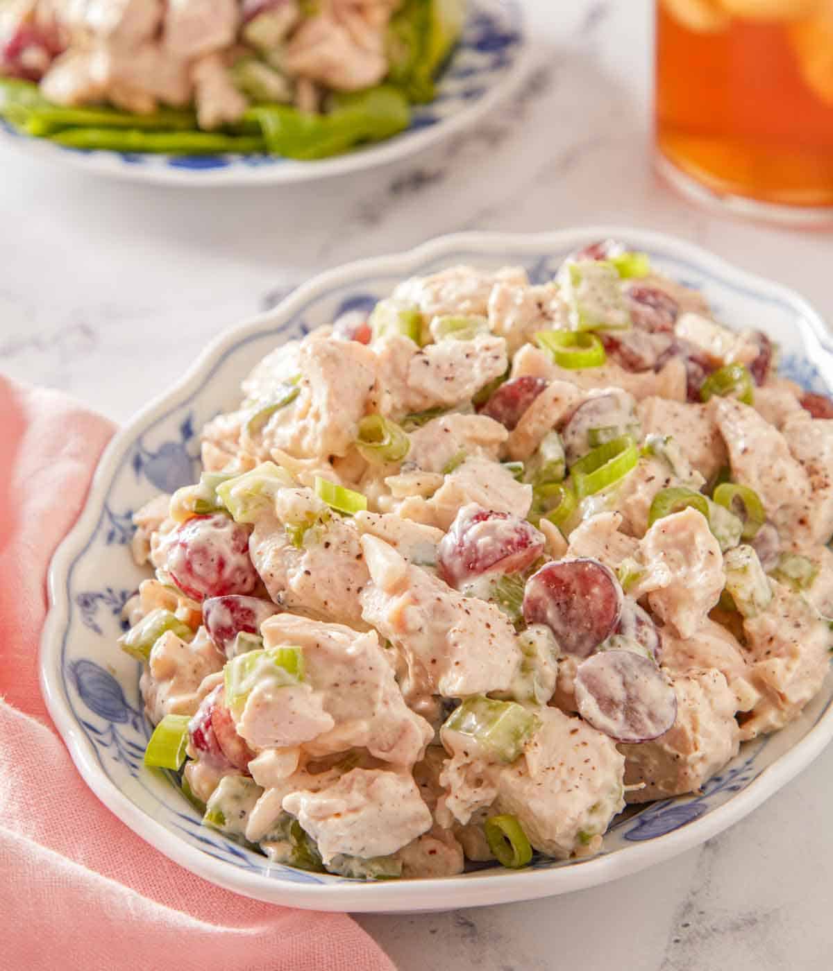 A small platter of chicken salad with gree onions on top.
