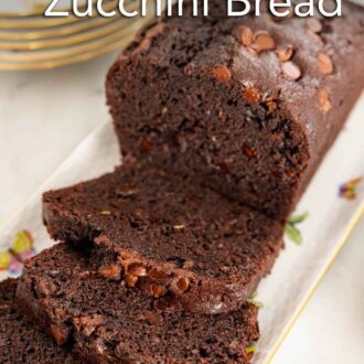 Pinterest graphic of a platter with a loaf of chocolate zucchini bread with slices cut.