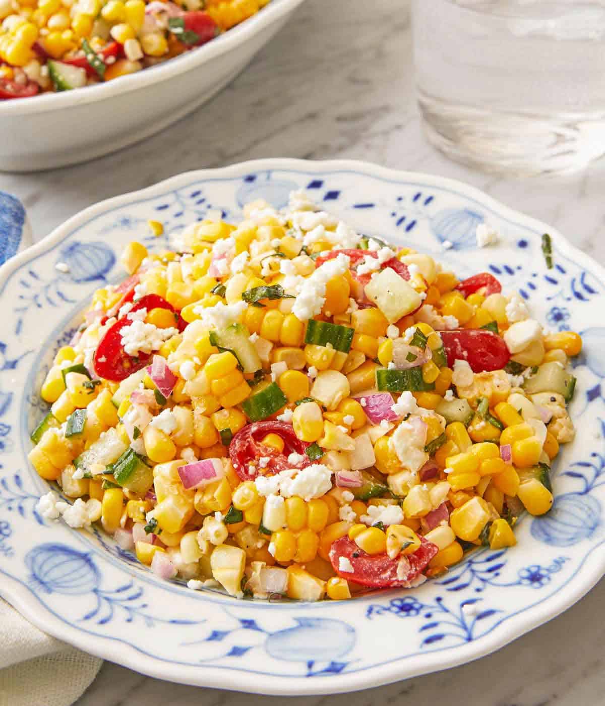 A plate of corn salad with crumbled feta on top.