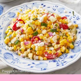 Pinterest graphic of a plate of corn salad with a glass of water in the background.