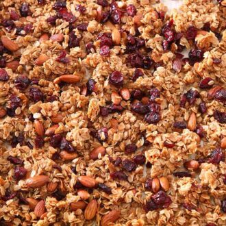 A sheet pan full of granola with a pink linen napkin on the side.